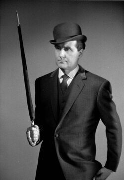 John Steed from the Avengers. Middle aged man in suit and bowler hat holding umbrella