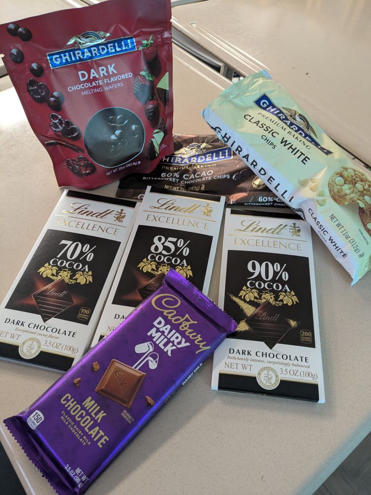 Various bars   & packages of chocolate. Whit milk and dark.