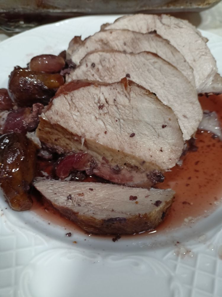 Plato de lomo con guarnición de higos y uvas al vino.