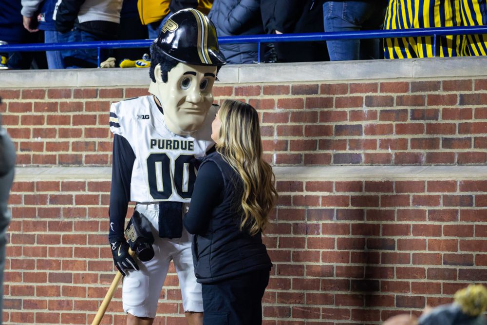 Purdue Pete looks down at a blonde woman in Michigan stadium like they might be a couple but he looks sad and creepy