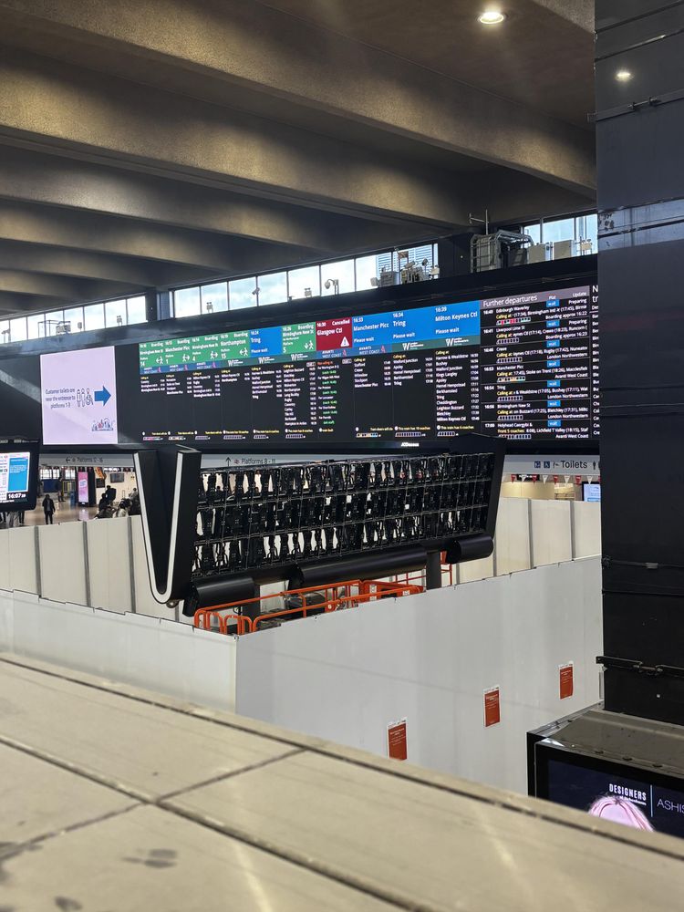 Hoarding around an information display array at Euston station And a view into the compound showing screen segments removed 