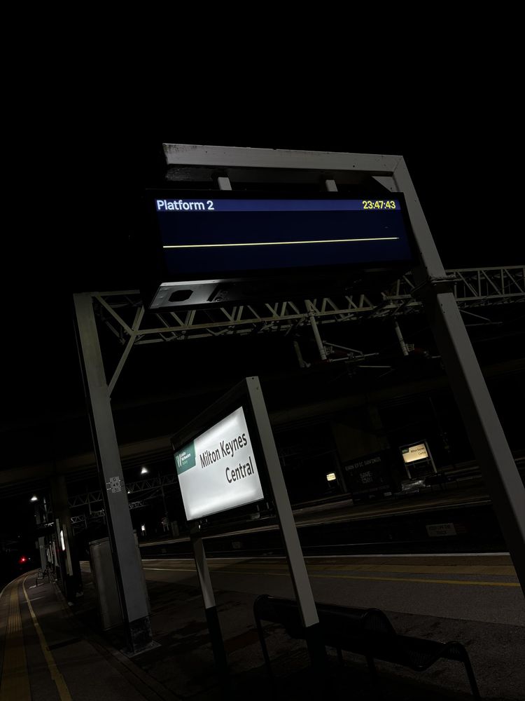 Information screen at Milton Keynes Central with the time of 2347 shown