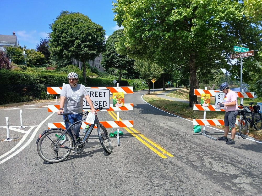 Street closed signs with folks standing by to block the road