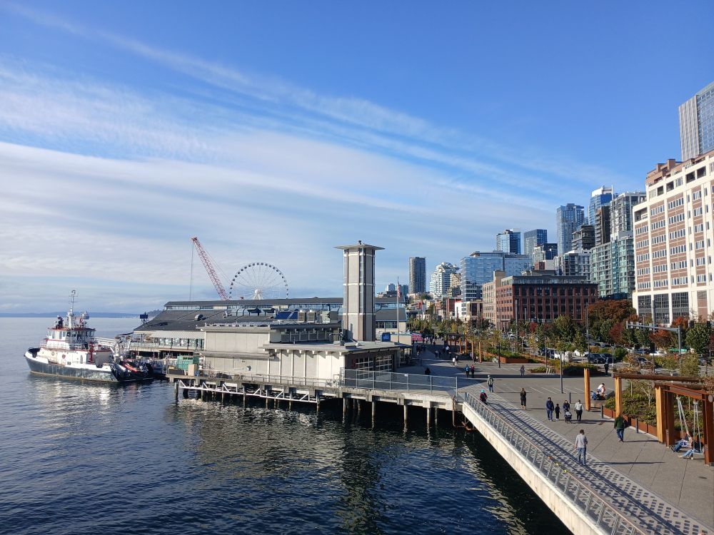 Downtown waterfront looking north from Colman Dock with a fireboat at the dock and wispy clouds over the water