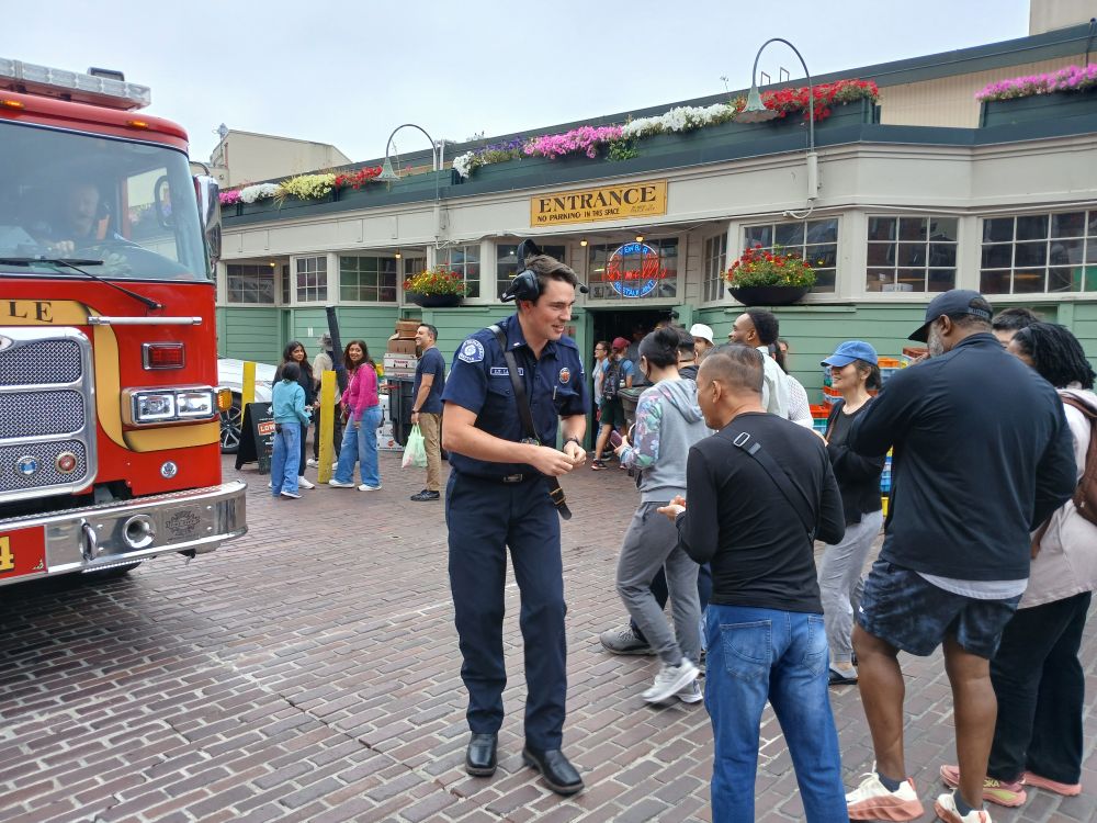 SFD responder handing out stickers to Pike Place visitors