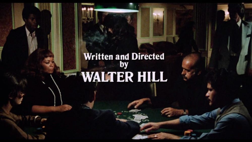 Screenshot from the credits of the Driver. It shows people playing poker. In the middle is written "Written and Directed by Walter Hill"