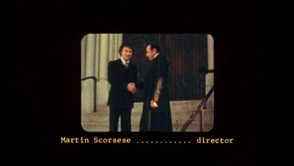 Screenshot from the credits of Mean Streets (1973)
It shows old footage of Harvey Keitel’s character shaking hands with a priest. 
Beneath, it says : « Martin Scorsese…….. director »