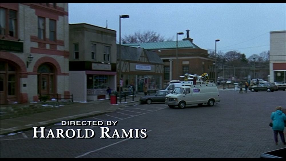 Screenshot from the credits of Groundhog Day. It shows a white television van parking. In the bottom left corner, it says "Directed by Harold Ramis"