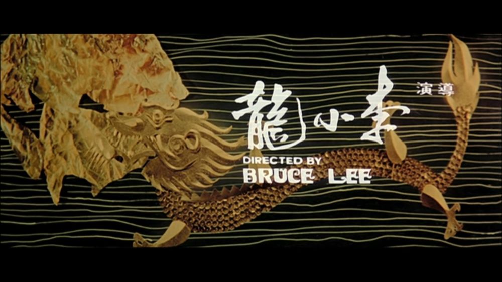 Screenshot from The Way of the Dragon (1972)
A golden dragon on lines in the background. Text is both English and Cantonese, says “directed by Bruce Lee“