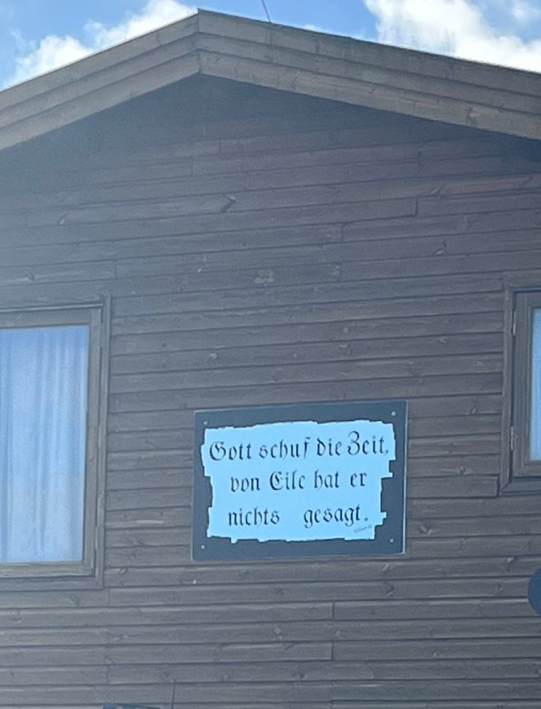Ein Schild im Hafen von Wangerooge mit der Aufschrift “Gott schuf die Zeit von Eile hat er nichts gesagt “