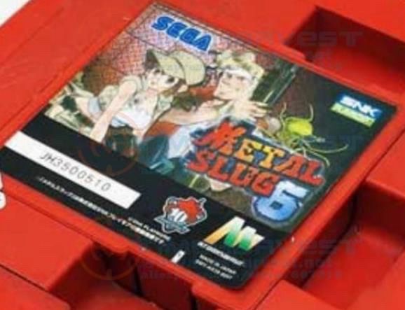 A close up shot of an Atomiswave cart inserted into the Atomiswave board housing. On top of the cart there’s a sticker that identifies the game as SNK PLAYMORE’S arcade version of Metal Slug 6, complete with a key art image of some of the game’s playable characters.