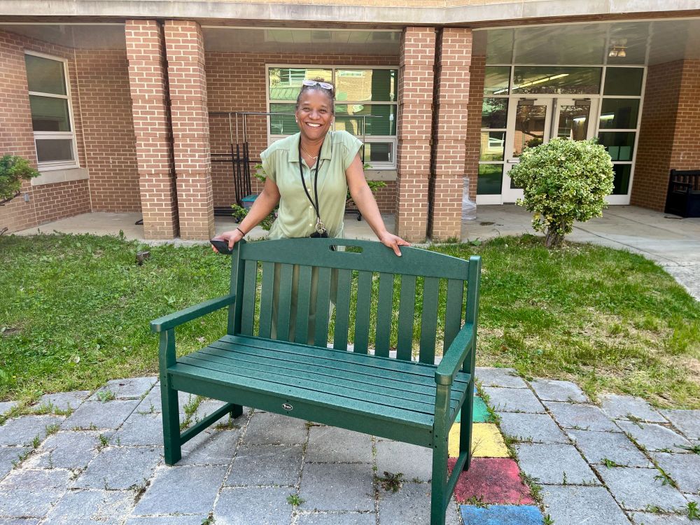 Principal De La Cruz Scales with our new TREX bench in the courtyard.