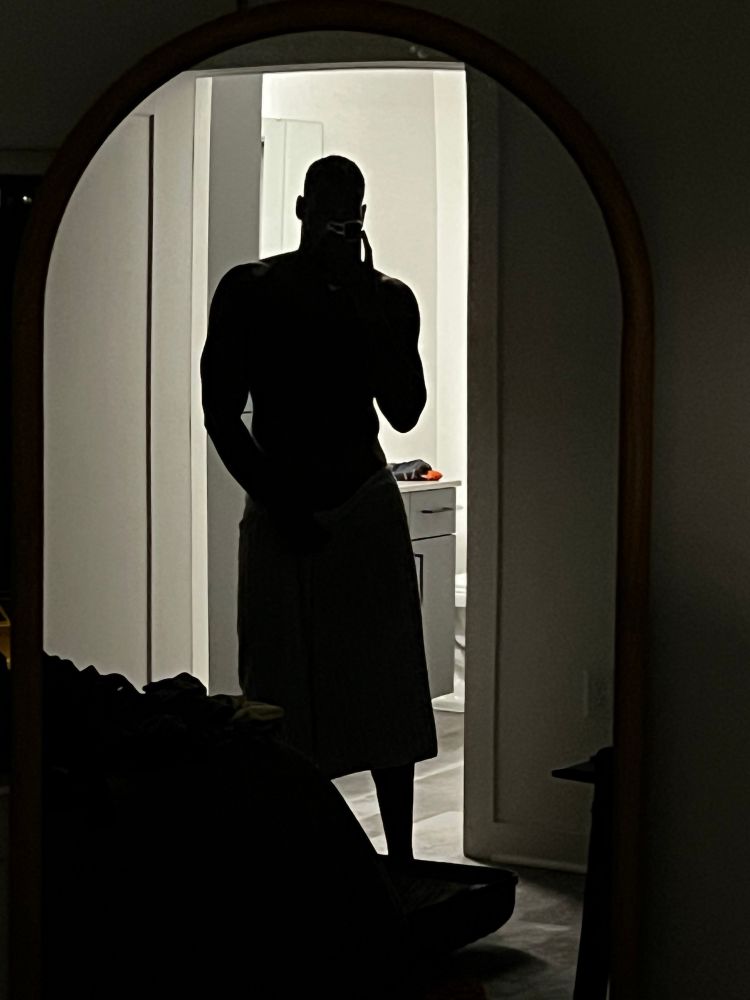 another selfie but backlit in a dark room so you only see a dark figure