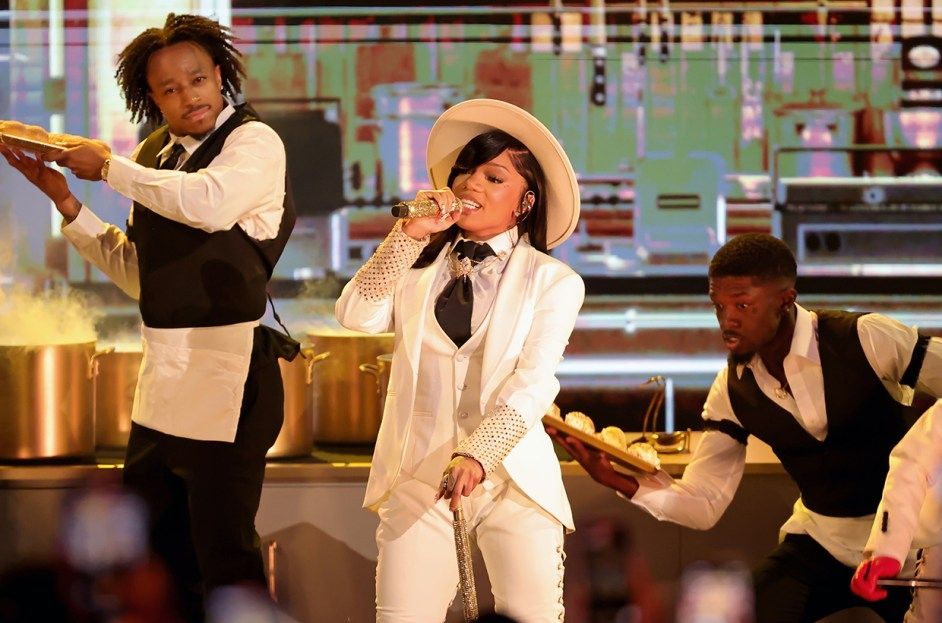 Rapper GloRilla performs "Let Her Cook" at the BET awards in a white suit and hat. Her backup dancers are dressed as servers.