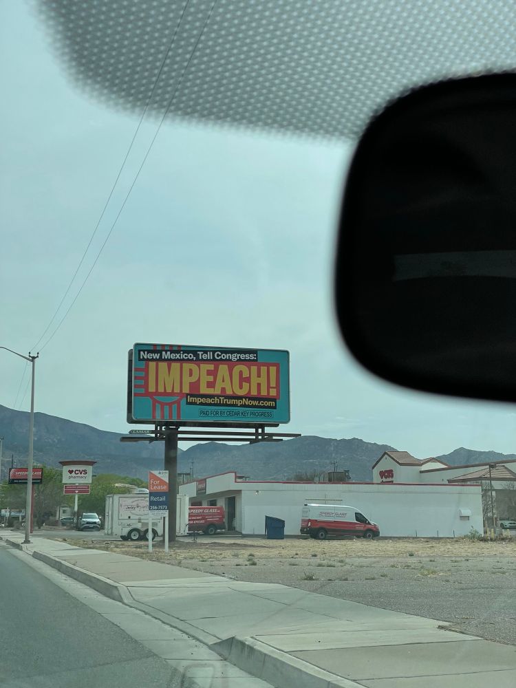 billboard that reads "New Mexico, Tell Congress:
IMPEACH!"
