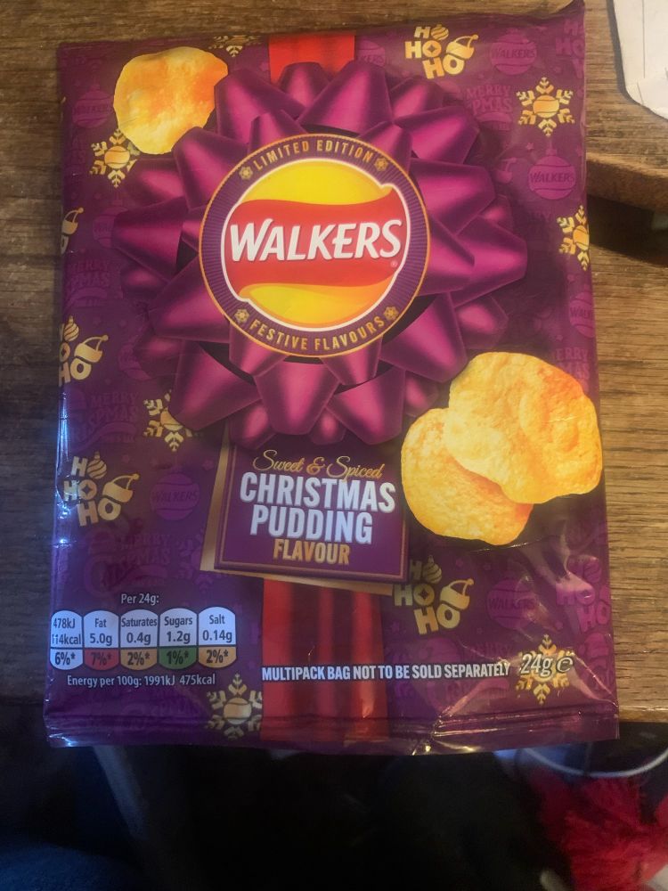 A packet of walkers crisps/chips in a purple packet and flavoured as Christmas Pudding