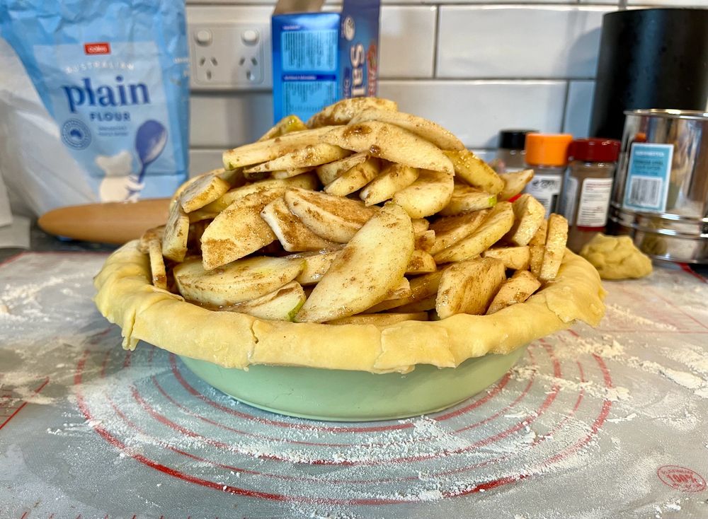 A pie dish piled high with sliced apples