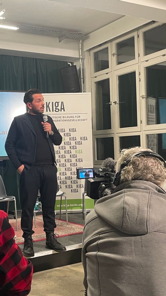 Derviş Hizarci spricht auf der Bühne