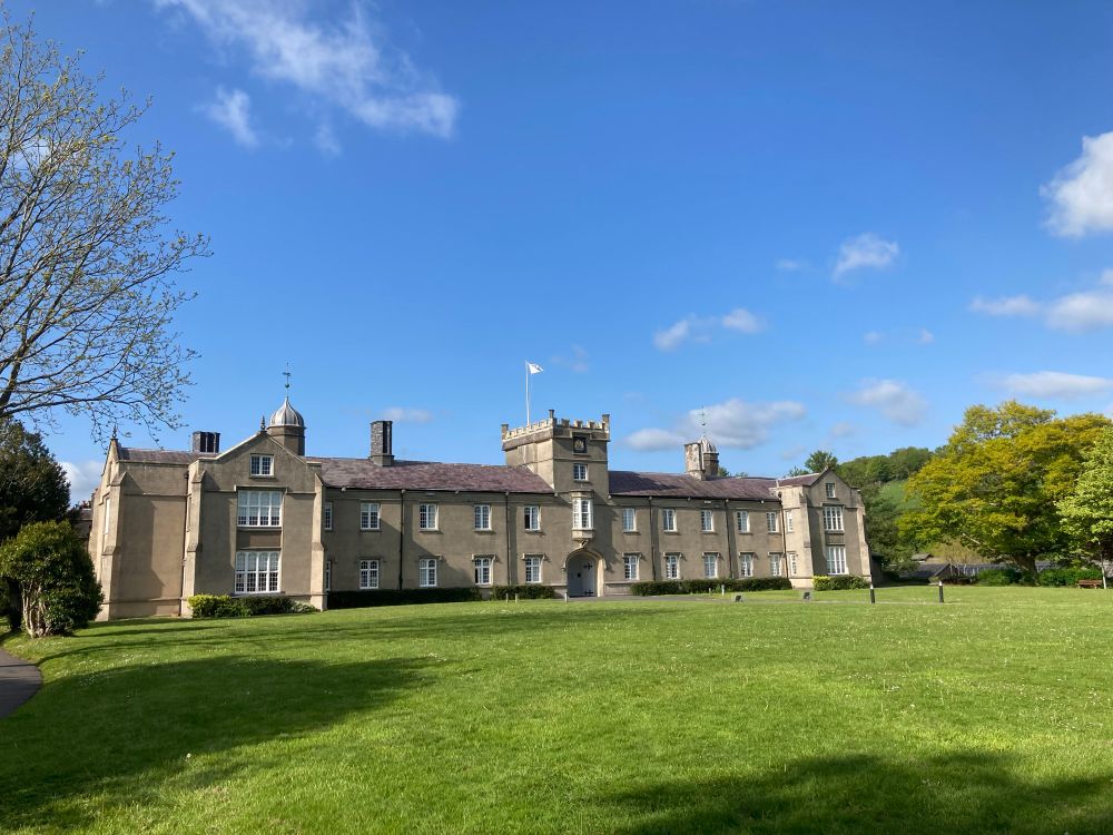 Old College at Lampeter, with rolling lawn in the foreground and blue skies 