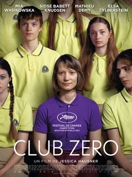 A poster for the movie "Club Zero." In the center is Mia Wasikowska in a purple short sleeve shirt. She is sitting facing the camera with her hands clasped in her lap. She has a slight smile. Sitting around her are the actors who portray her pupils in the movie. They all wear identical yellow short sleeve shirts with tan shorts. They all face the camera with expressionless looks on their faces. One pupil looks at Wasikowska adoringly. 