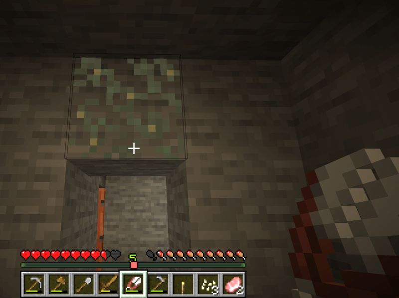 Minecraft stone blocks with one block covered in light green moss that gently glows. in bottom right metal shears are visible