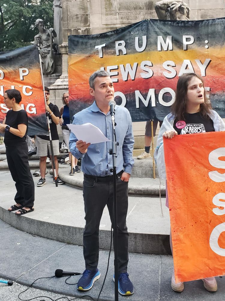Peter Bienart standing outside speaking into a mic 