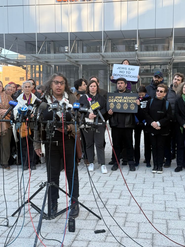 Professor Sonya Posmentier, New York University, Sanctuary Campus Network speaking in front of crowd with “Jews say no to deportations” signs at press conference to free Mahmoud Khalil 