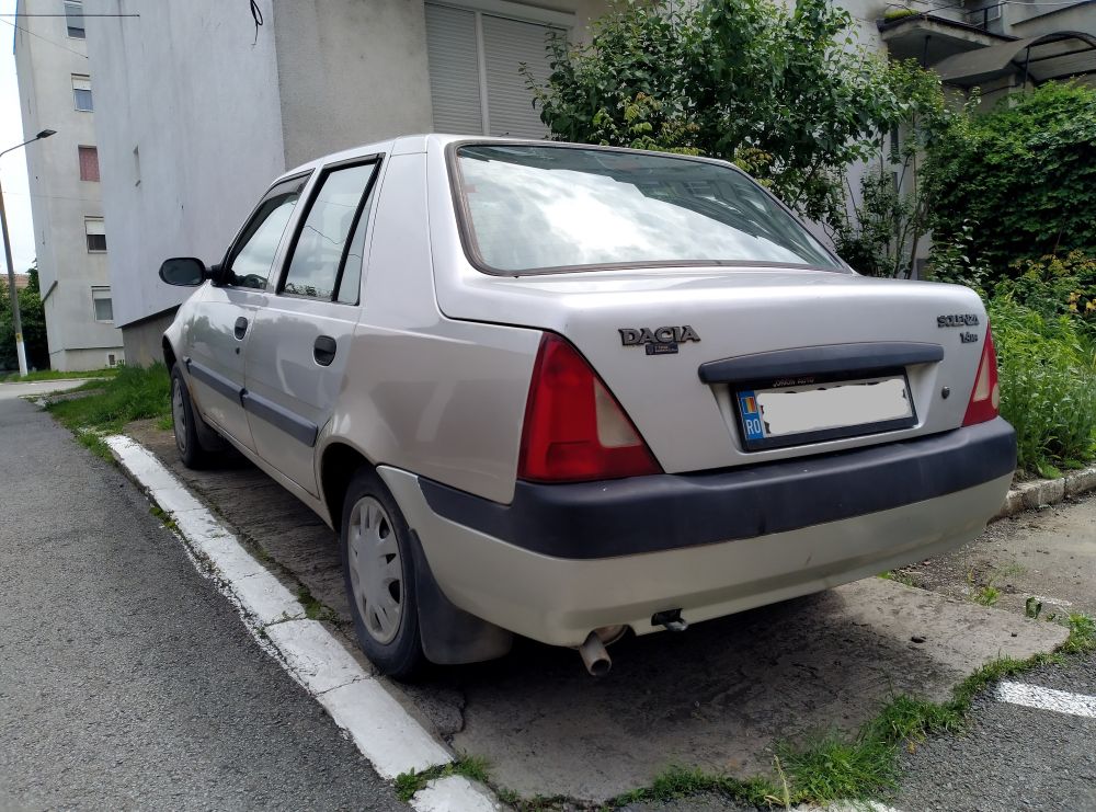Rear and left side view of silver Dacia Solenza liftback car parked on a street