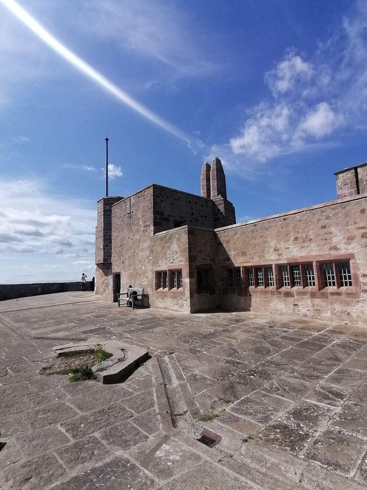 Arts and Crafts court yard with blue sunny sky above.