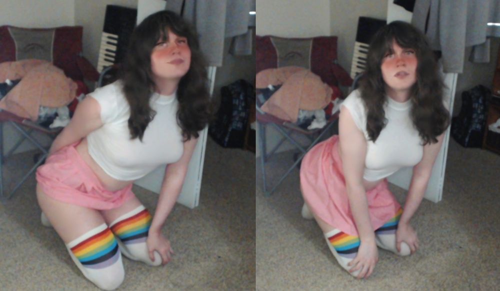 Me wearing white socks with a rainbow trim, pink skirt, white sleeveless shirt, on my knees