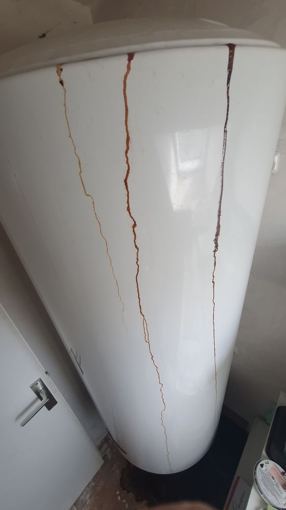 Photo d'un chauffe eau electrique qui fuit de la rouille par le haut