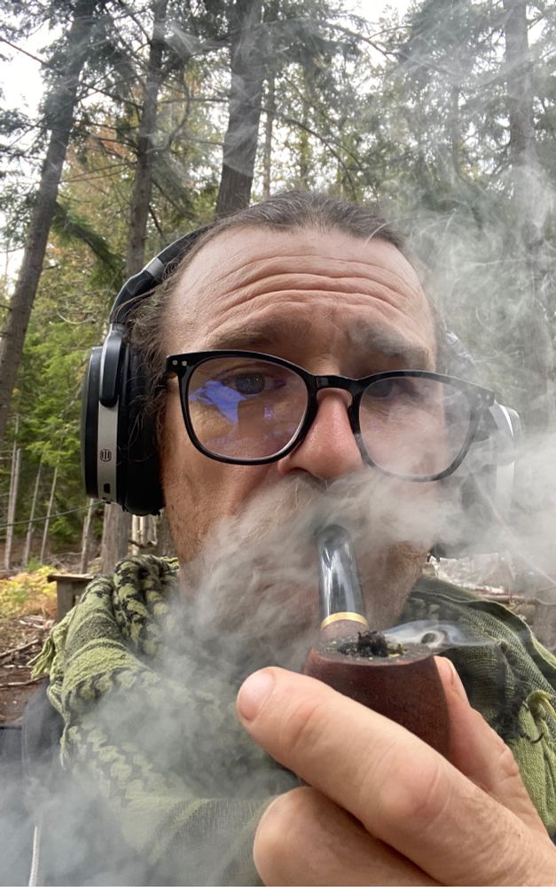 It’s a pic of me in the woods blowing smoke out my nose, smoking a cherrywood pipefilled with indica, topped with todays freshly rubbed charas