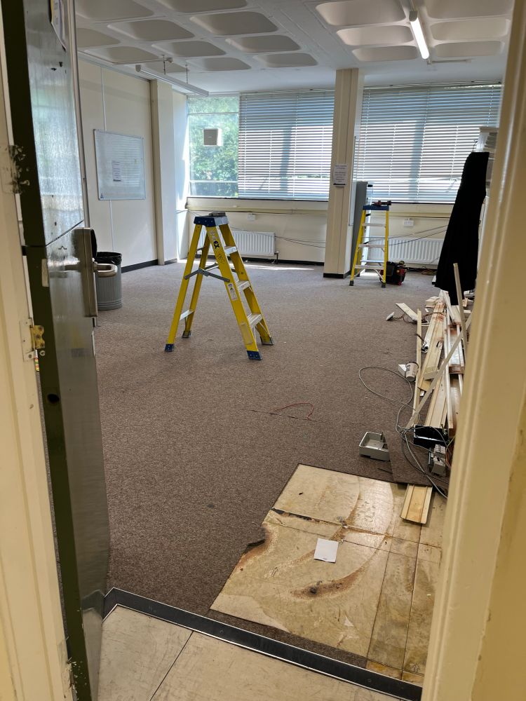 Student common room empty except for a stepladder and pieces of shelving 