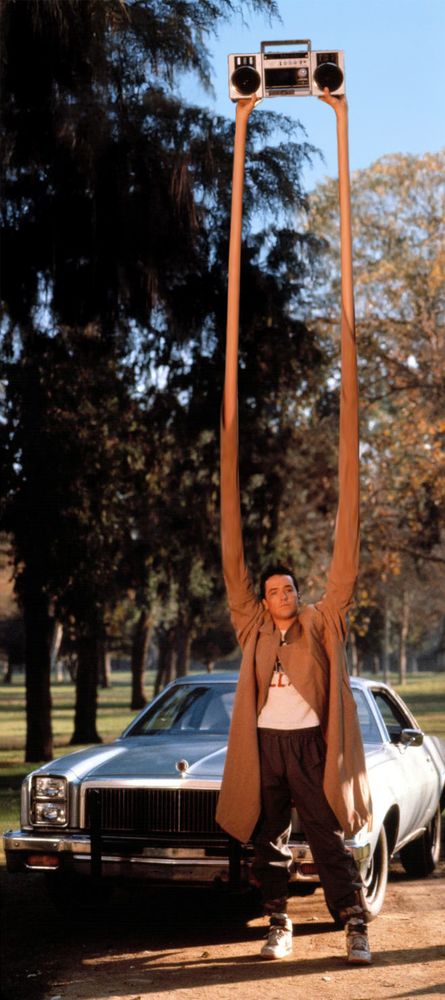 The one scene from Say Anything anyone would recognize, but with long arms. Imagine he's playing Longarm by Wall of Voodoo
