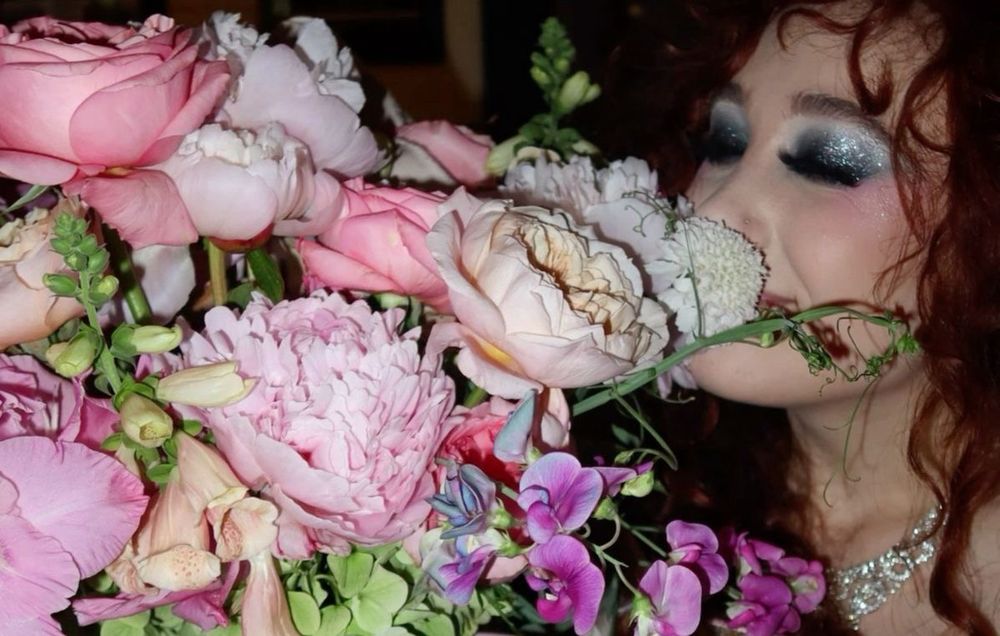 Chappell Roan smelling pink flowers
