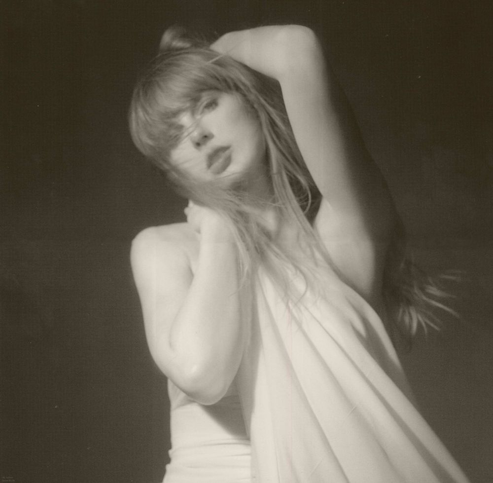 Taylor Swift from TTPD photoshoot. Shes holding her dress and she has one arm behind her head