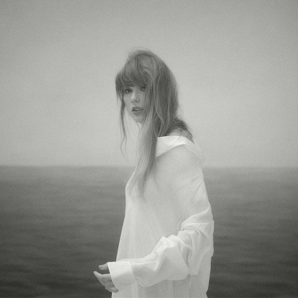taylor swift wearing white with the ocean behind her
