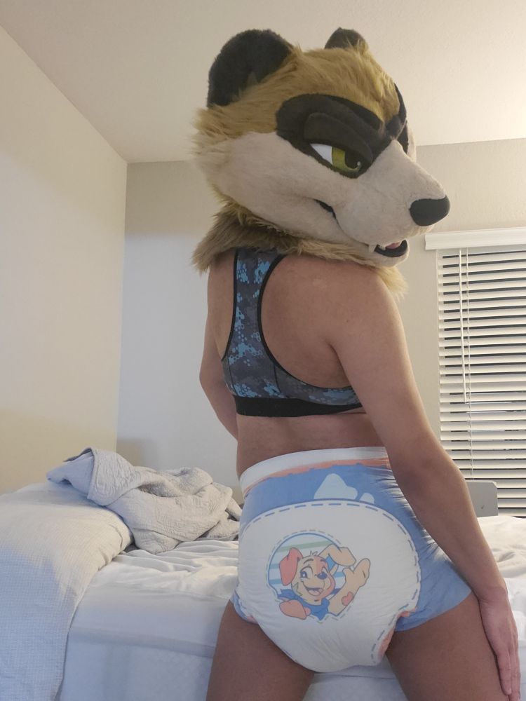 Ferret fursuiter now showing off the back of the diaper while looking back at it. There's so much padding. And Patches is waving at you!