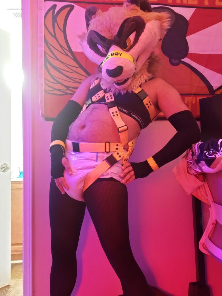 Same scene only ferret fursuiter is now leaning to the right side and rubbing their diaper