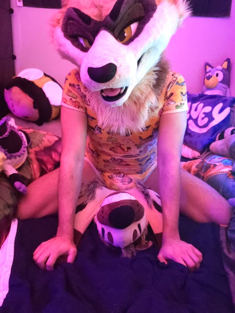 Ferret fursuiter has flipped hyena plush on their back and is holding their paws down, rubbing their diaper bulge on their chest