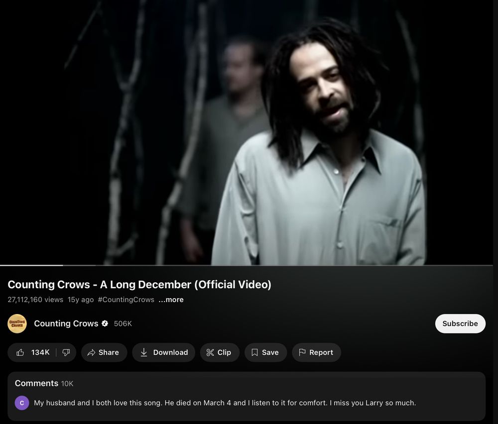 A screenshot of the music video for the counting crows a long December on YouTube. A still of Adam Duritz in the center of the screen, and a comment that reads my husband and I both love this song. He died on march 4 and I listen to it for comfort. I miss Larry so much. 