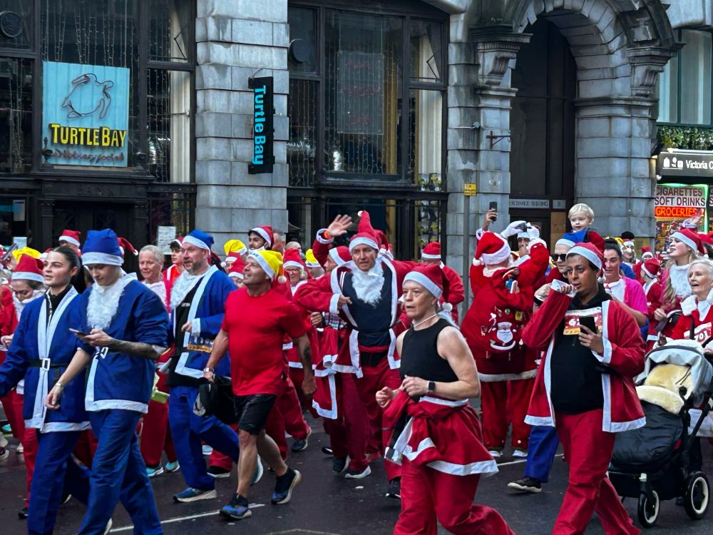 Some Everton supporting Santas wearing Blue costumes amongst the large group of tradition red costumes in liverpools Santa dash - joke