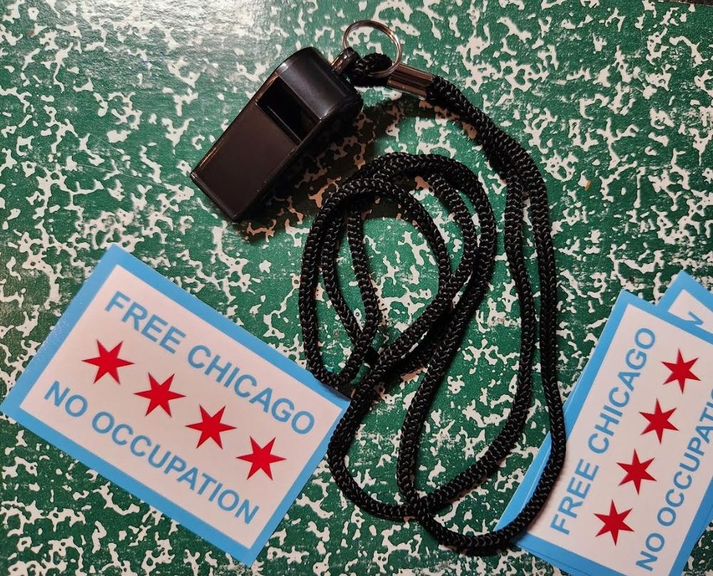 Picture of some "Free Chicago - No occupation" stickers and a black whistle