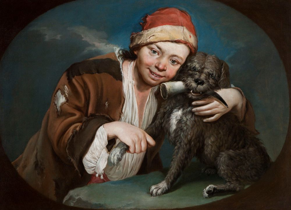 A young boy poses for a portrait in clothes that indicate he is intended to portray a poor beggar. He stands with one arm around his dog, holding his paw in his other hand as if making his dog wave to the viewer.