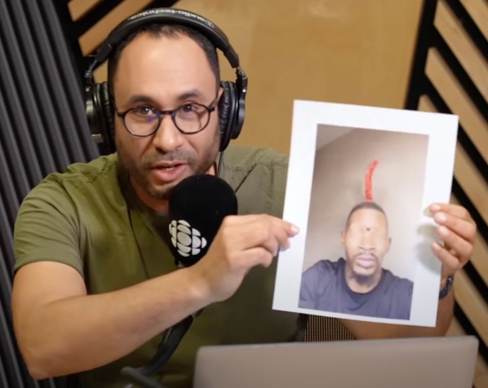 Alexis de Lancer tient une feuille sur laquelle sur trouve le mème "Eye of Rah".