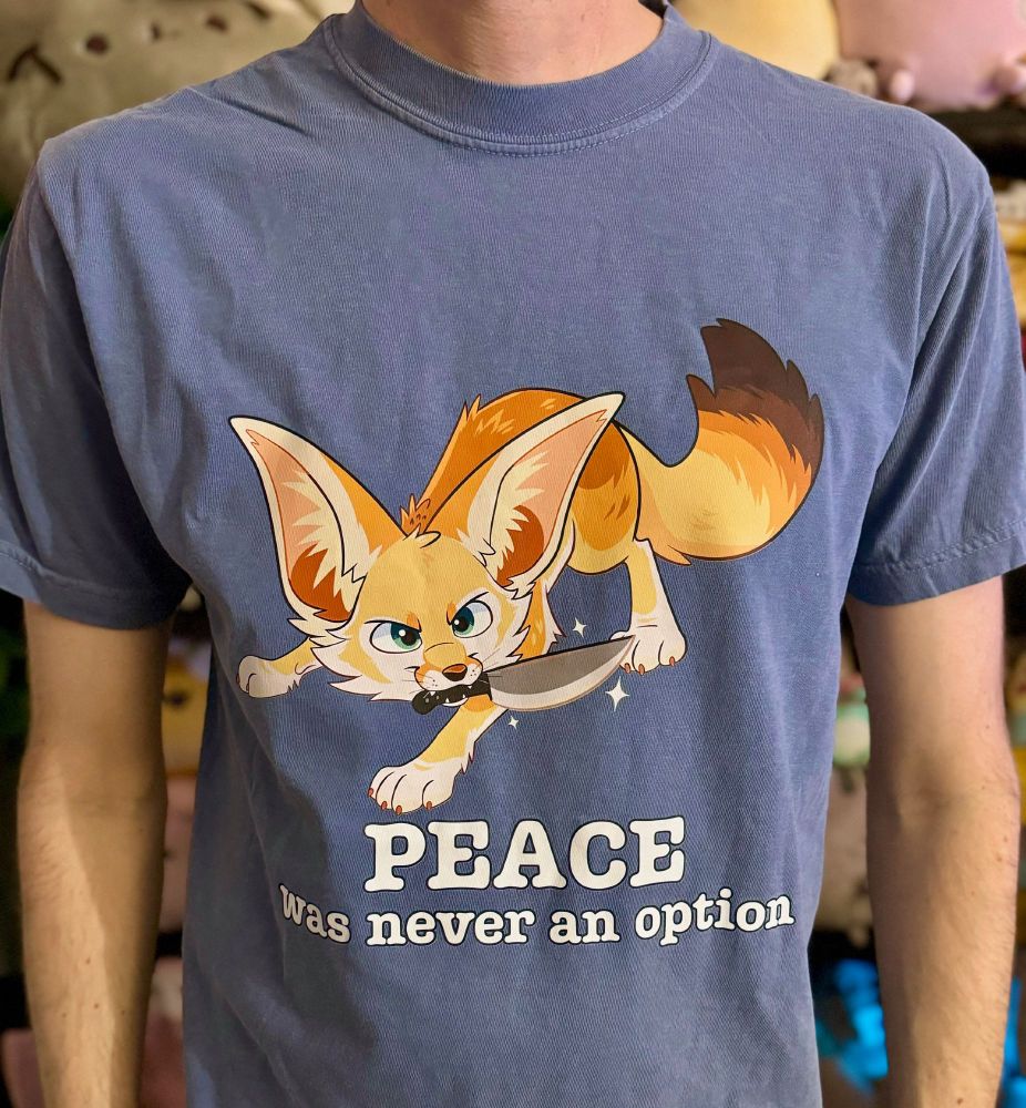 A graphic tshirt of a fennec fox holding a knife with an up to no good expression. The text reads: Peace was never an option. 