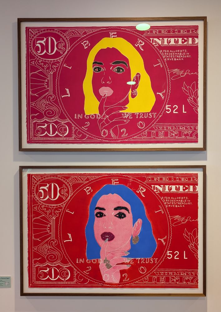 Framed prints on an off-white wall: Money Dua IV (top) and Dua Lipa Sparkles (bottom), both by Maricela Sanchez. Each is an image of Dua Lipa appearing on modified United States paper currency.