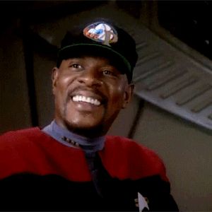 a man wearing a star trek uniform and a baseball cap