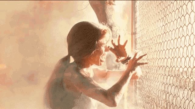 Gif animado de Terminator. En él, Sarah Connor es pasto de las llamas. Grita aferrada a un valla metálica.