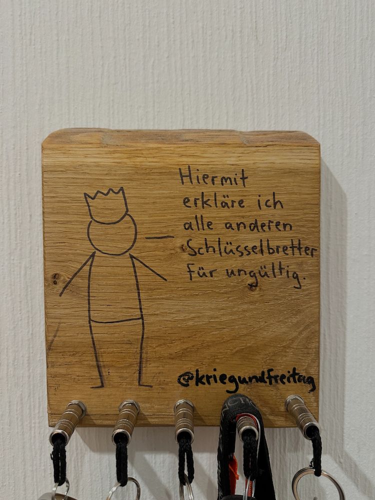 Schlüsselbrett mit einem KriegundFreitag Strichmännchen das sagt "Hiermit erkläre ich alle anderen Schlüsselbretter für ungültig". Die Schlüssel werden mit Klinkensteckern befestigt. 